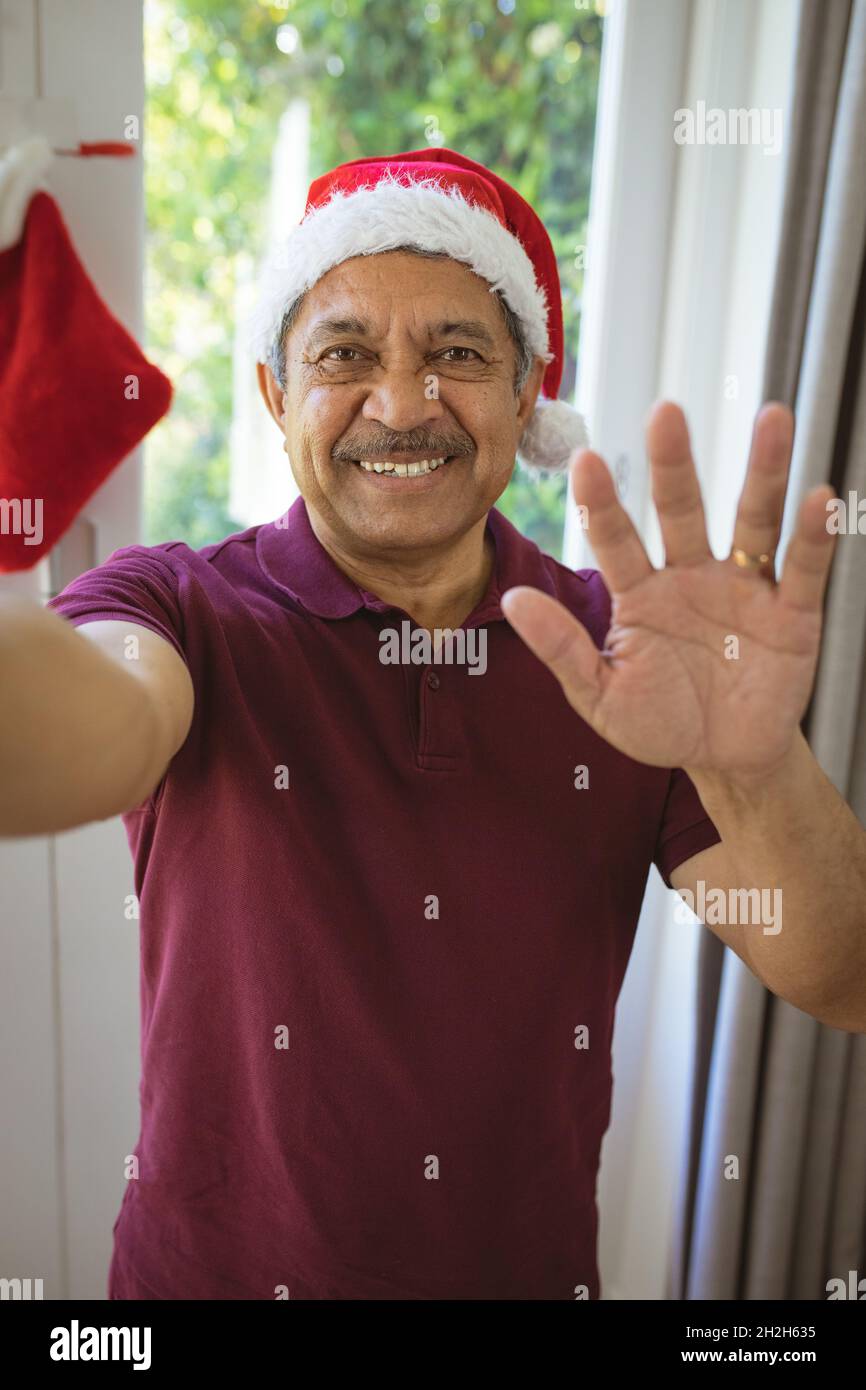 Ritratto di felice biraciale anziano in santa Hat fare videochiamata di natale Foto Stock