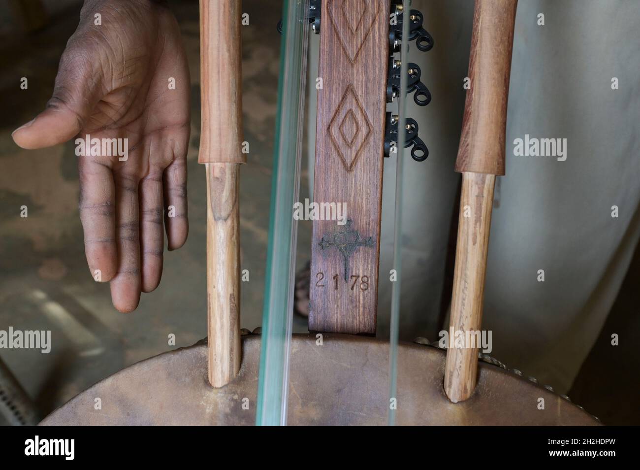 SENEGAL, monastero benedettino Keur Moussa, i monaci lavorano in officina per costruire l'arpa ponte africano Kora , marchiando con croce e numero Foto Stock