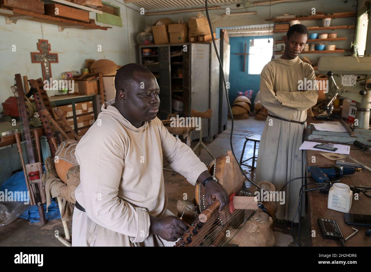 SENEGAL, monastero benedettino Keur Moussa, i monaci lavorano in officina per costruire l'arpa ponte africano Kora, sintonizzando il tradizionale strumento a corda Foto Stock