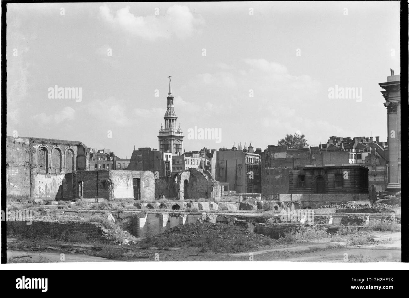 St Mary-le-Bow Church, Cheapside, City and County of the City of London, Greater London Authority, 1941 - 1945. Una vista che guarda a sud-est attraverso una bomba paesaggio danneggiato verso la chiesa di St Mary-le-Bow, con un angolo di Sala Goldsmiths appena visibile sulla destra. St Mary-le-Bow fu ricostruita da Christopher Wren dopo il Grande incendio di Londra nel 1666. Durante la seconda guerra mondiale fu quasi distrutta dai bombardamenti del 10 maggio 1941 con bombe incendiarie che provocarono un incendio che mandò le campane nella sua torre che si schiantavano a terra. La torre fu lasciata in piedi e il restauro della chiesa iniziò nel 1956. Foto Stock