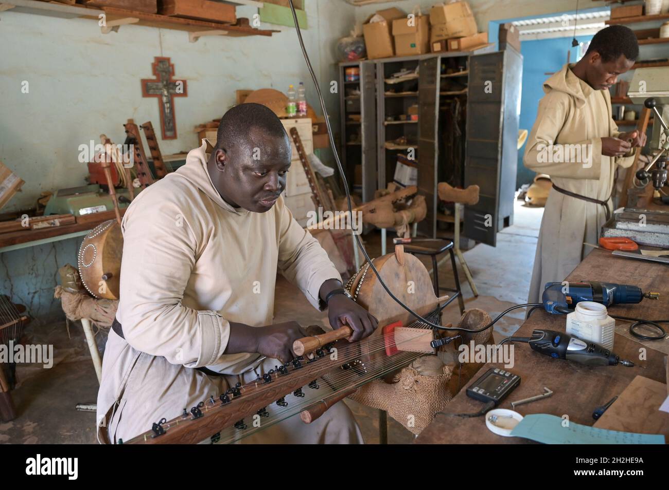 SENEGAL, monastero benedettino Keur Moussa, i monaci lavorano in officina per costruire l'arpa ponte africano Kora, sintonizzando il tradizionale strumento a corda Foto Stock