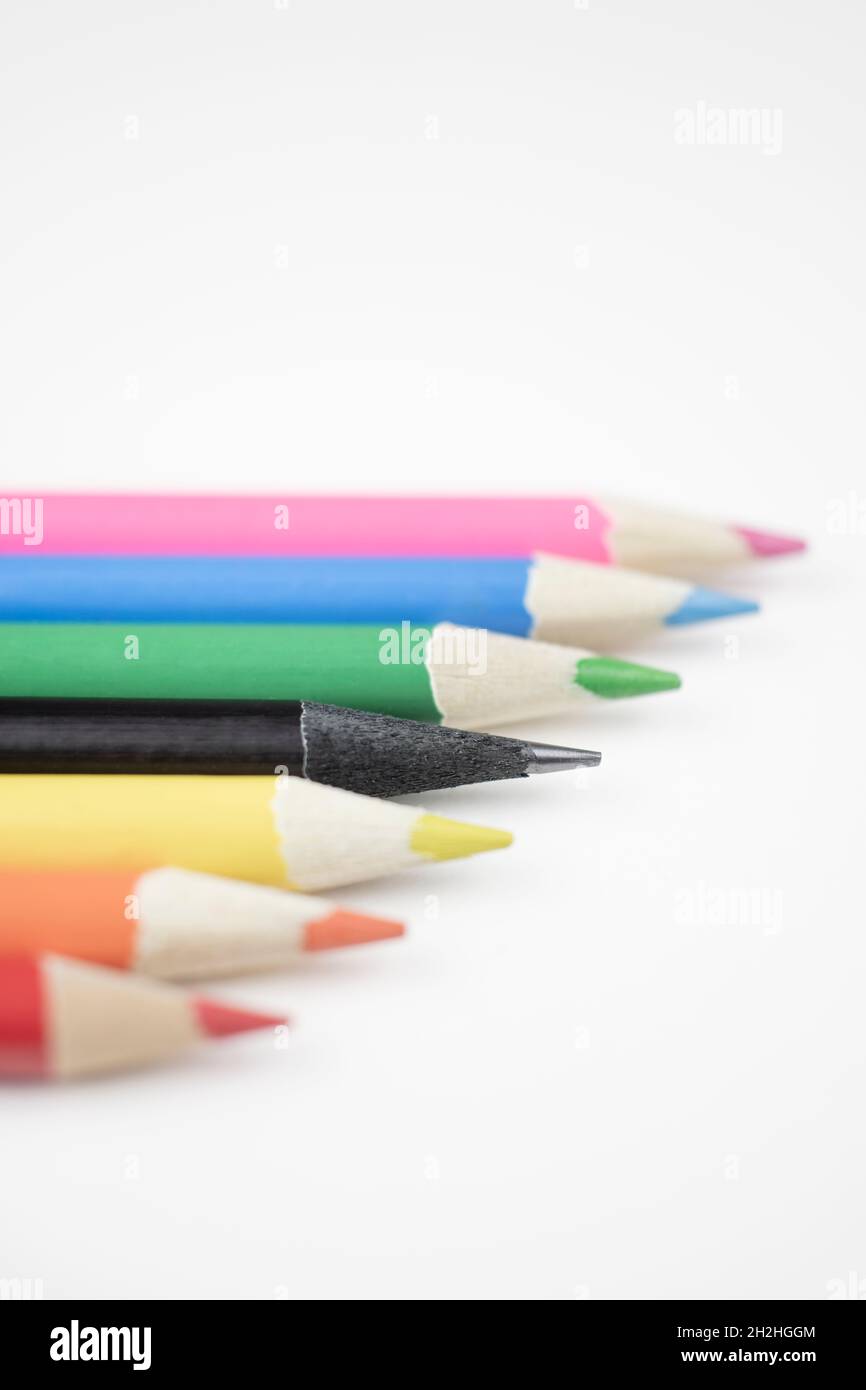 Fila di matite colorate, con una dispari in nero. Foto Stock