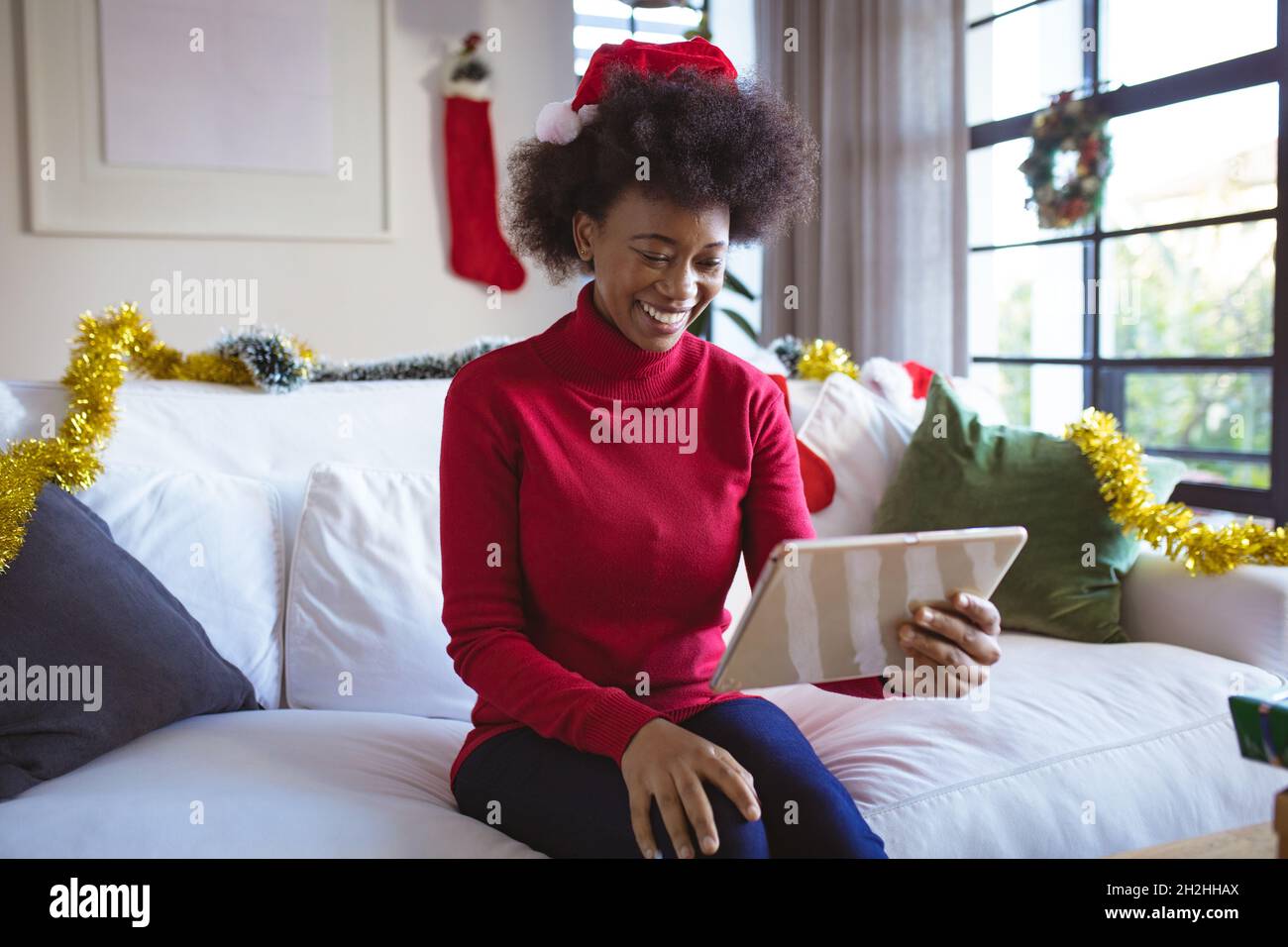 Felice afroamericana donna in santa Hat fare tablet natale videochiamata Foto Stock