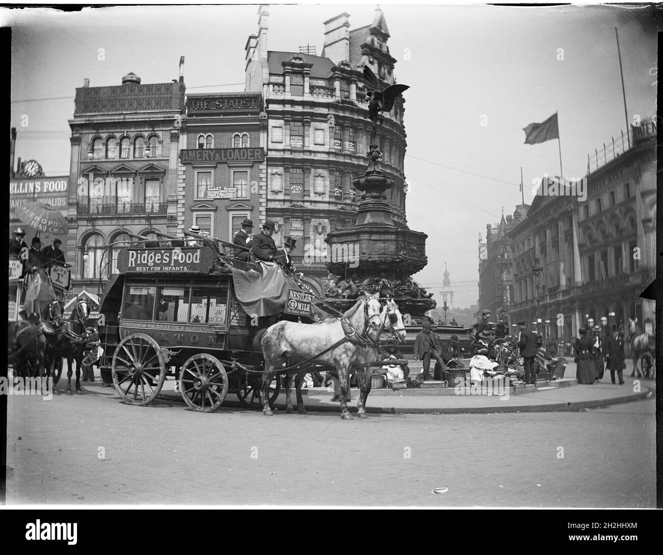 Shaftesbury Memorial Fountain, Piccadilly Circus, City of Westminster, Greater London Authority, 1895-1905. Una vista di Piccadilly Circus da sud-ovest che mostra autobus trainati da cavalli che passano davanti e venditori di strada seduti intorno alla Shaftesbury Memorial Fountain (conosciuta anche come Eros). Questa fotografia sembra essere stata scattata tra il 1895-1905 e quindi sembra improbabile che la fotografia sia stata scattata da Charles William Prickett, nato nel 1896. Le fotografie del resto della sua collezione sono state scattate tra il 1920 e il 1940. Foto Stock