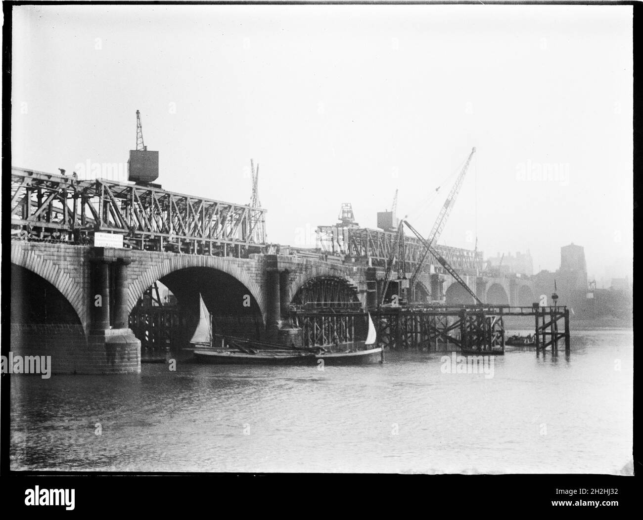 Demolizione di Waterloo Bridge, Lambeth, Greater London Authority, 1936. Una vista sul Tamigi che mostra il vecchio Waterloo Bridge in demolizione con una chiatta del Tamigi che passa sotto di esso. Il Waterloo Bridge è stato progettato da John Rennie ed è stato aperto nel 1817. Fu demolita negli anni '30 con un altro ponte che lo sostituì negli anni '40. Foto Stock