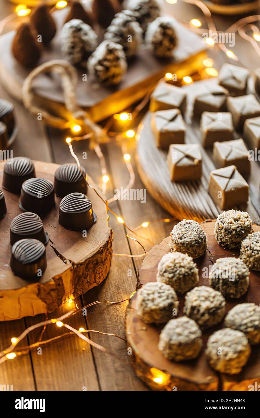 Cioccolatini assortiti su tavola di legno con ghirlone Foto Stock