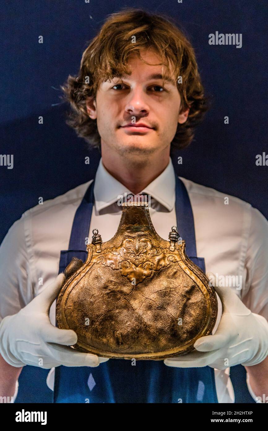 Londra, Regno Unito. 22 ottobre 2021. Una rara pelle ottomana matara (fiasca), Turchia, XVI/XVII secolo - ex nella collezione di Sir Walter Scott, stima: £50,000-70,000 - un monumentale piatto di ceramica Iznik con vitigni d'uva, Turchia, circa 1530, stima: £250,000-350,000 - Anteprima per le Arti del mondo islamico & India vendita a Sotheby's London. Oltre 1,000 anni di oggetti storici, dipinti e manoscritti saranno venduti il 27 ottobre. Credit: Guy Bell/Alamy Live News Foto Stock