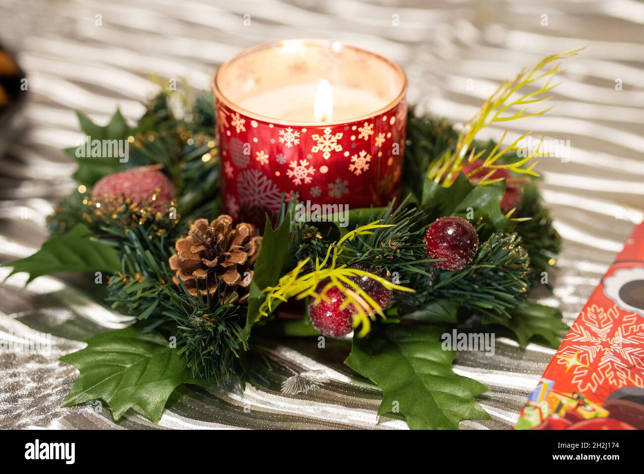 Candela che brucia e decorazione di Natale sullo sfondo del tavolo Foto Stock