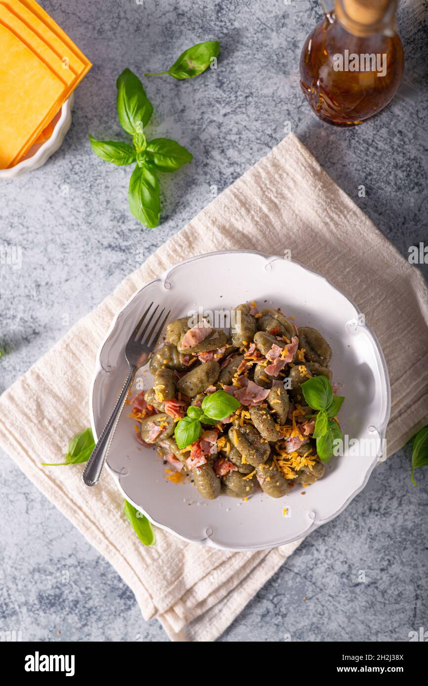 Gnocchi di spinaci fatti in casa con prosciutto e formaggio cheddar Foto Stock