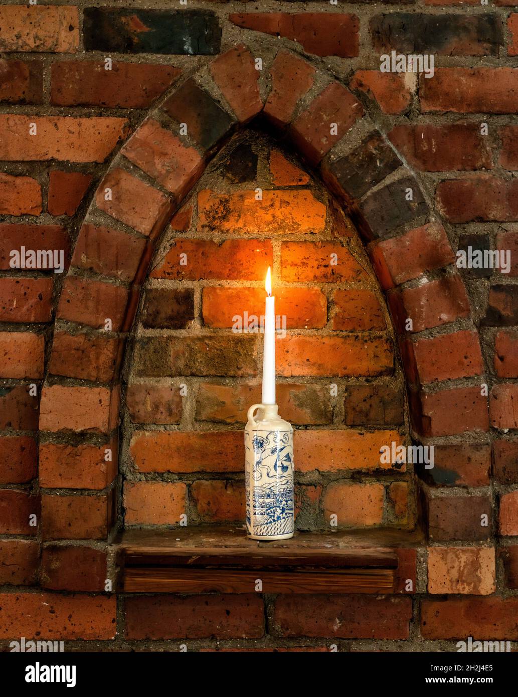 Lume di candela in alcova di mattoni Foto Stock