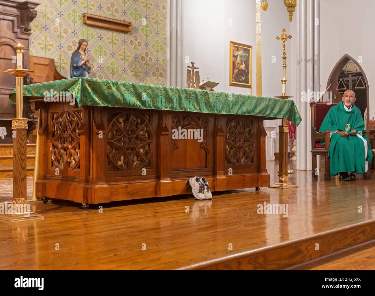 Detroit, Michigan - un paio di scarpe durante la messa all'altare della Chiesa cattolica della Santissima Trinità. Le scarpe sono state indossate da un rifugiato mentre viaggiava fr Foto Stock