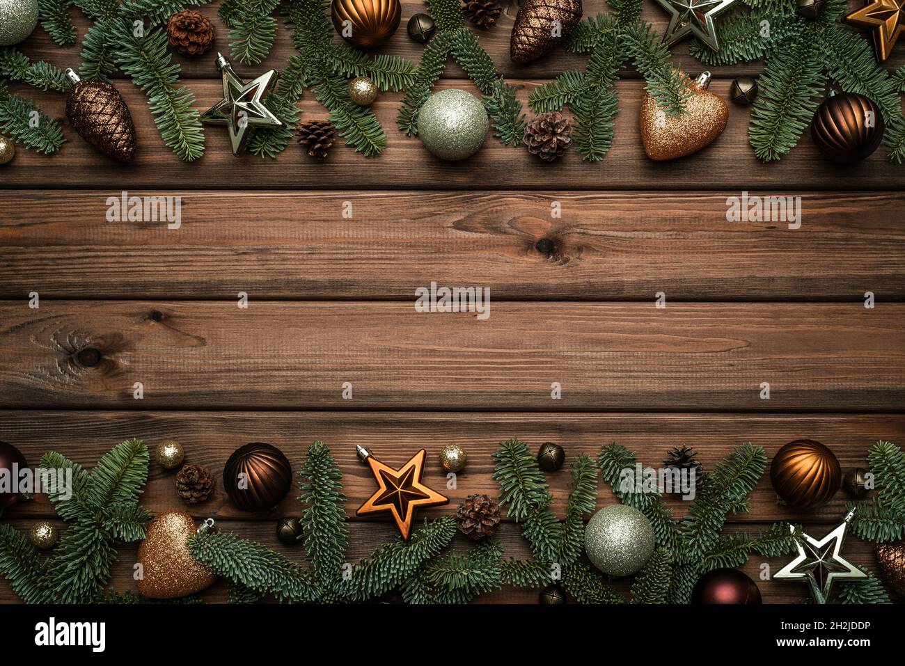 Sfondo vintage natalizio con cornice festiva fatta di rami decorati di abete e campane a slitta Foto Stock