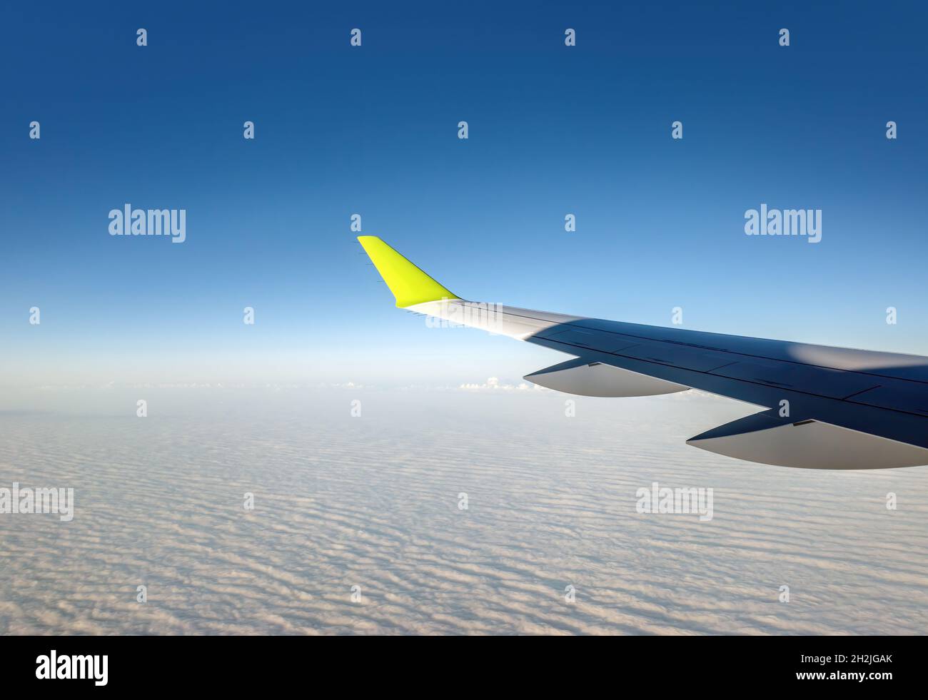 Volare nel cielo e nel mare di nuvole. Ala di aeroplano sopra le nuvole. Aeroplano con sfondo cielo blu chiaro. Vista da un'altezza sopra le nuvole Foto Stock