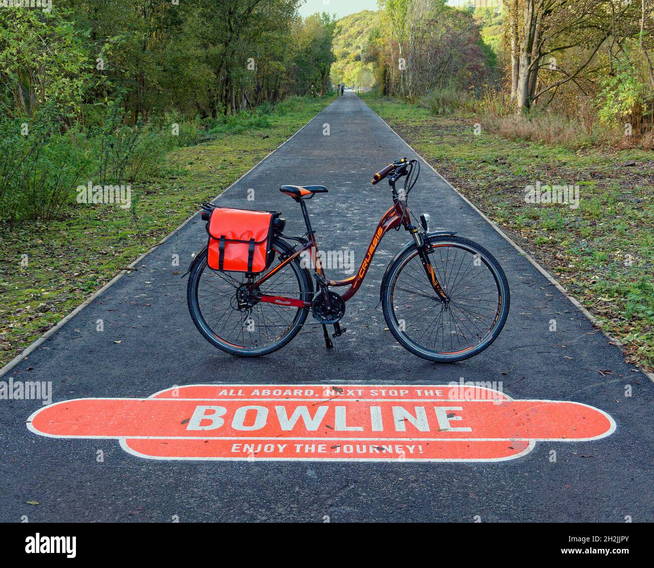 Bowling, Glasgow, Scozia, UK 22nd Ottobre, 2021.UK Meteo: Bici elettrica su Sunny nuovo bowling High line a Bowling come il famoso a New york si specchia sul vecchio ponte ferroviario vicino Glasgow. Dieci milioni di sterline sono stati spesi sulla pista ciclabile da glasgow a New york sul porto conosciuto come la bowline dopo l'aggiornamento. Il nuovo logo in sabbia bianca sul percorso ha messo i tocchi finali alla sua nascita, riflettendo il suo patrimonio ferroviario, mentre il percorso ciclabile per il lago lomond diventa senza traffico. Credit: Gerard Ferry/Alamy Live News Foto Stock