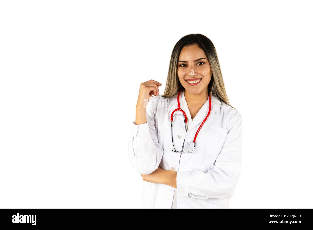 Un giovane medico con il suo stetoscopio sorridente su sfondo bianco. Concetto di donna professionale, personale sanitario. Foto Stock