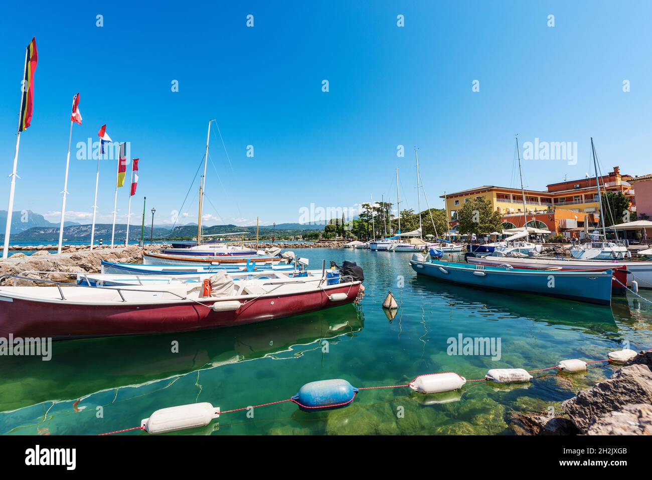 Porto del piccolo borgo di Cisano con piccole barche ormeggiate. Località turistica sulla costa del Lago di Garda. Comune di Bardolino, provincia di Verona, Italia. Foto Stock