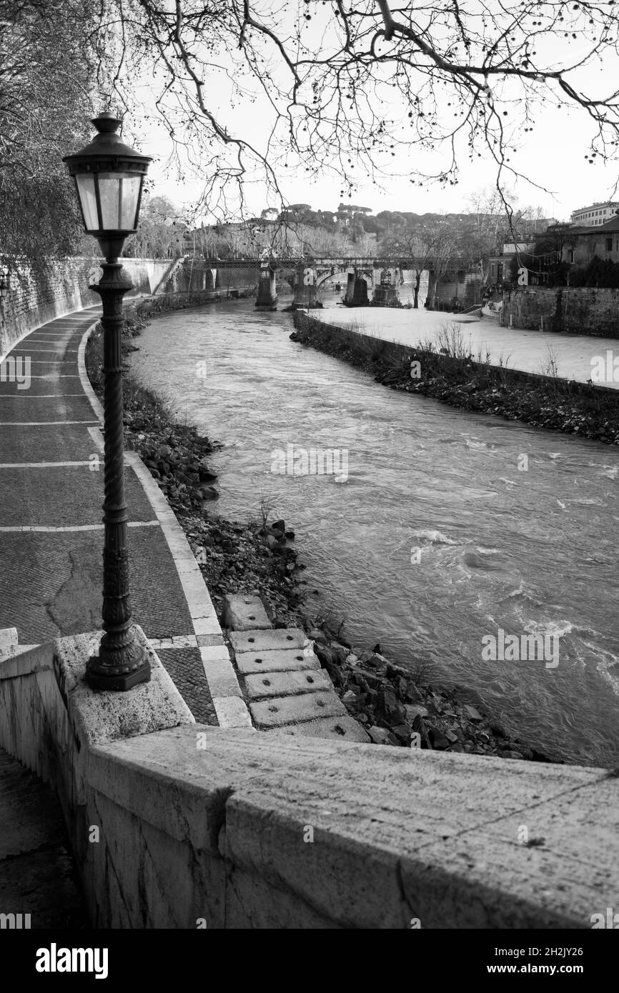 Riva del Tevere con luci di strada d'epoca, Roma, Italia. Fotografia in bianco e nero Foto Stock