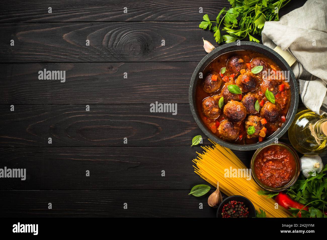 Polpette in salsa di pomodoro e pasta su tavola di legno scuro. Foto Stock