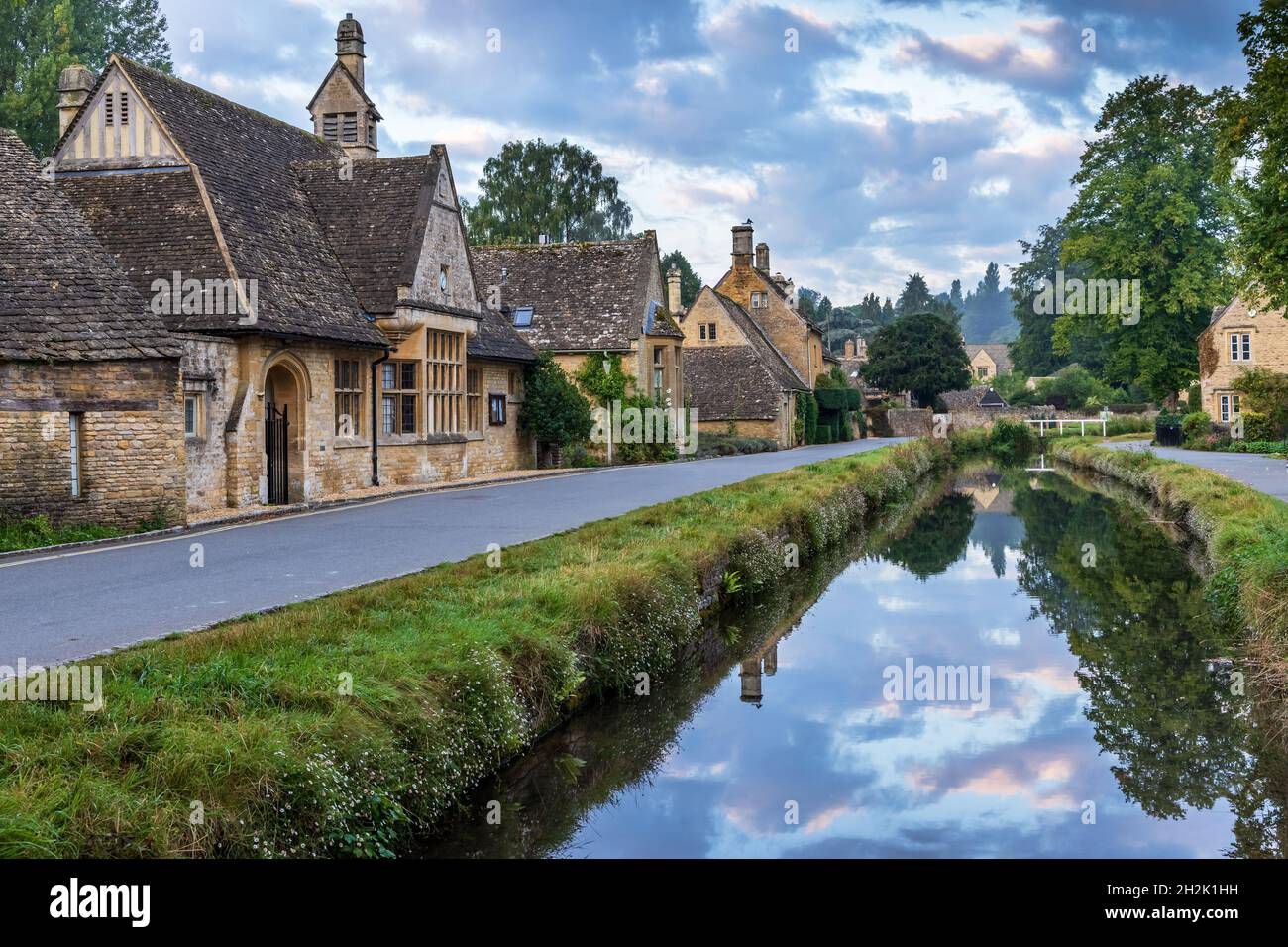 Cottage calcarei accanto al River Eye nel pittoresco villaggio di Cotswold di macellazione inferiore in Gloucestershire, Inghilterra. Foto Stock