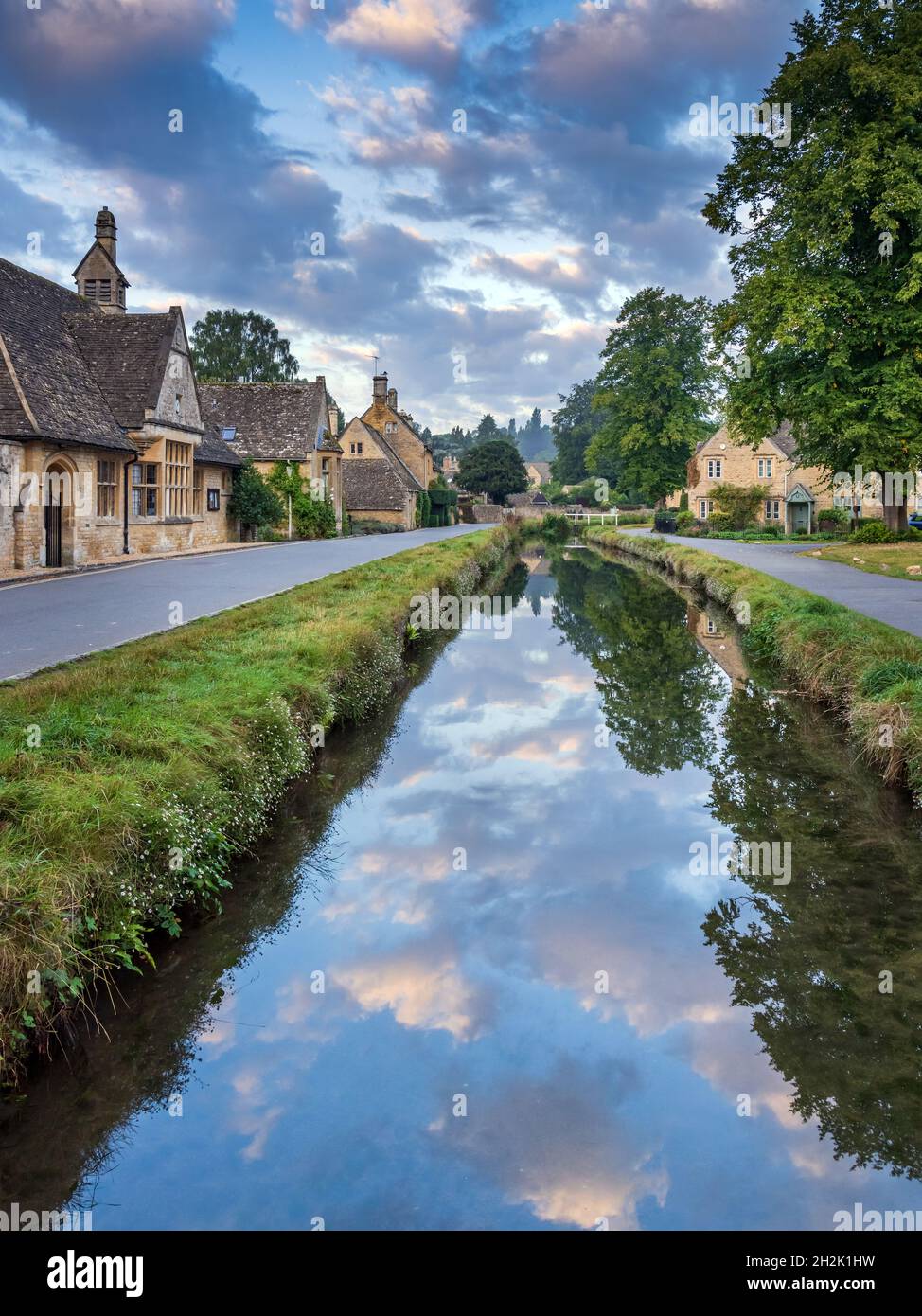 Cottage calcarei accanto al River Eye nel pittoresco villaggio di Cotswold di macellazione inferiore in Gloucestershire, Inghilterra. Foto Stock