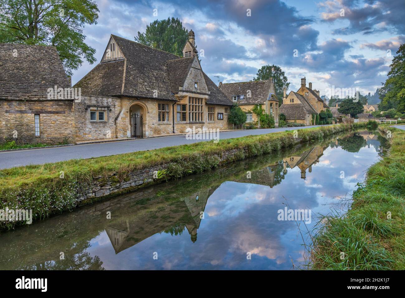 Cottage calcarei accanto al River Eye nel pittoresco villaggio di Cotswold di macellazione inferiore in Gloucestershire, Inghilterra. Foto Stock