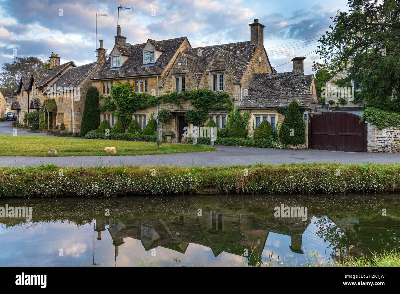 Cottage calcarei accanto al River Eye nel pittoresco villaggio di Cotswold di macellazione inferiore in Gloucestershire, Inghilterra. Foto Stock