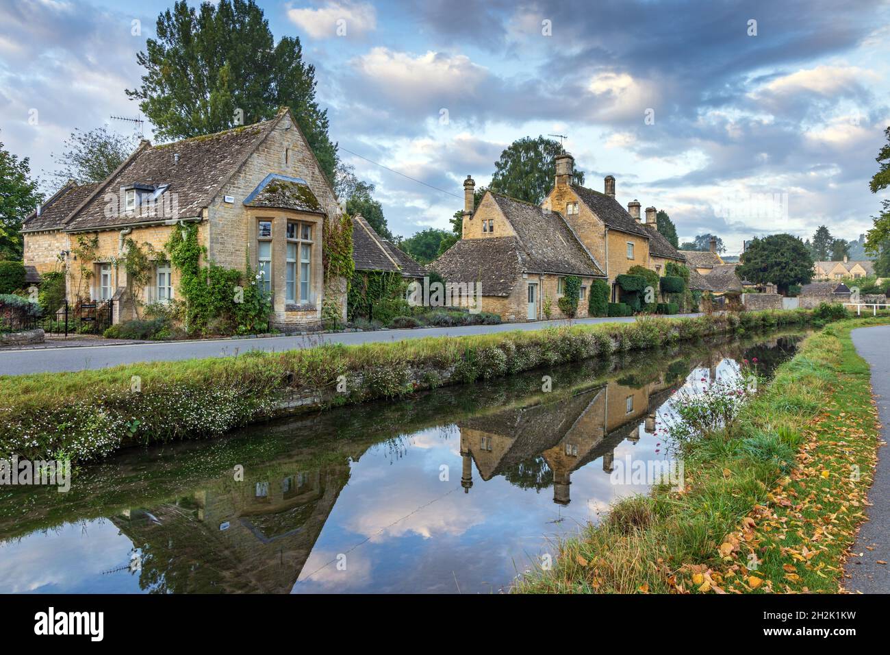 Cottage calcarei accanto al River Eye nel pittoresco villaggio di Cotswold di macellazione inferiore in Gloucestershire, Inghilterra. Foto Stock