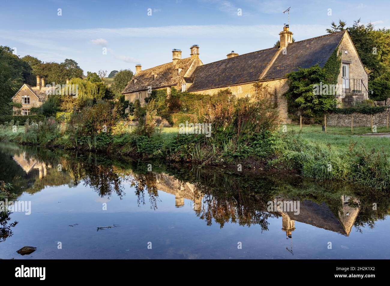 Graziosi cottage in pietra accanto al River Eye nel bellissimo villaggio di Cotswold di Upper Slaughter in Gloucestershire, Inghilterra. Foto Stock