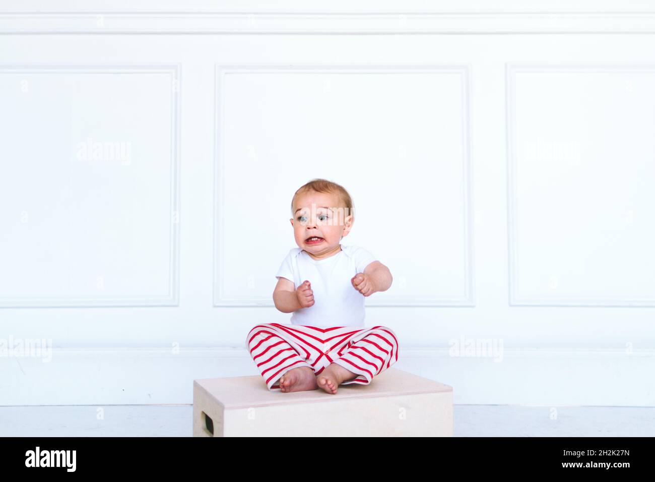 Un bambino fa un volto divertente in uno studio fotografico Foto Stock