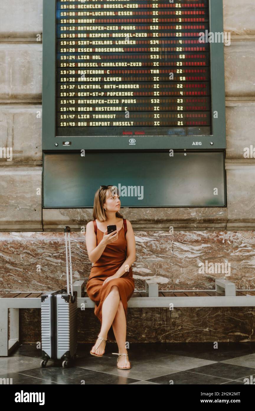 Donna turistica che cammina all'interno della stazione ferroviaria di Anversa Foto Stock