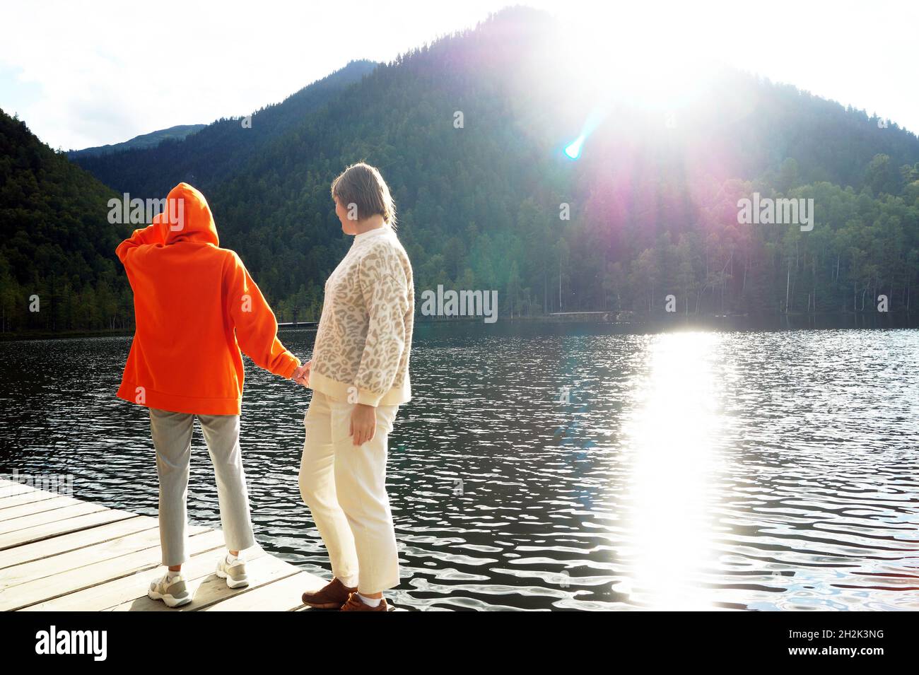 Figlia e madre camminano su un ponte di legno su laghi caldi Foto Stock
