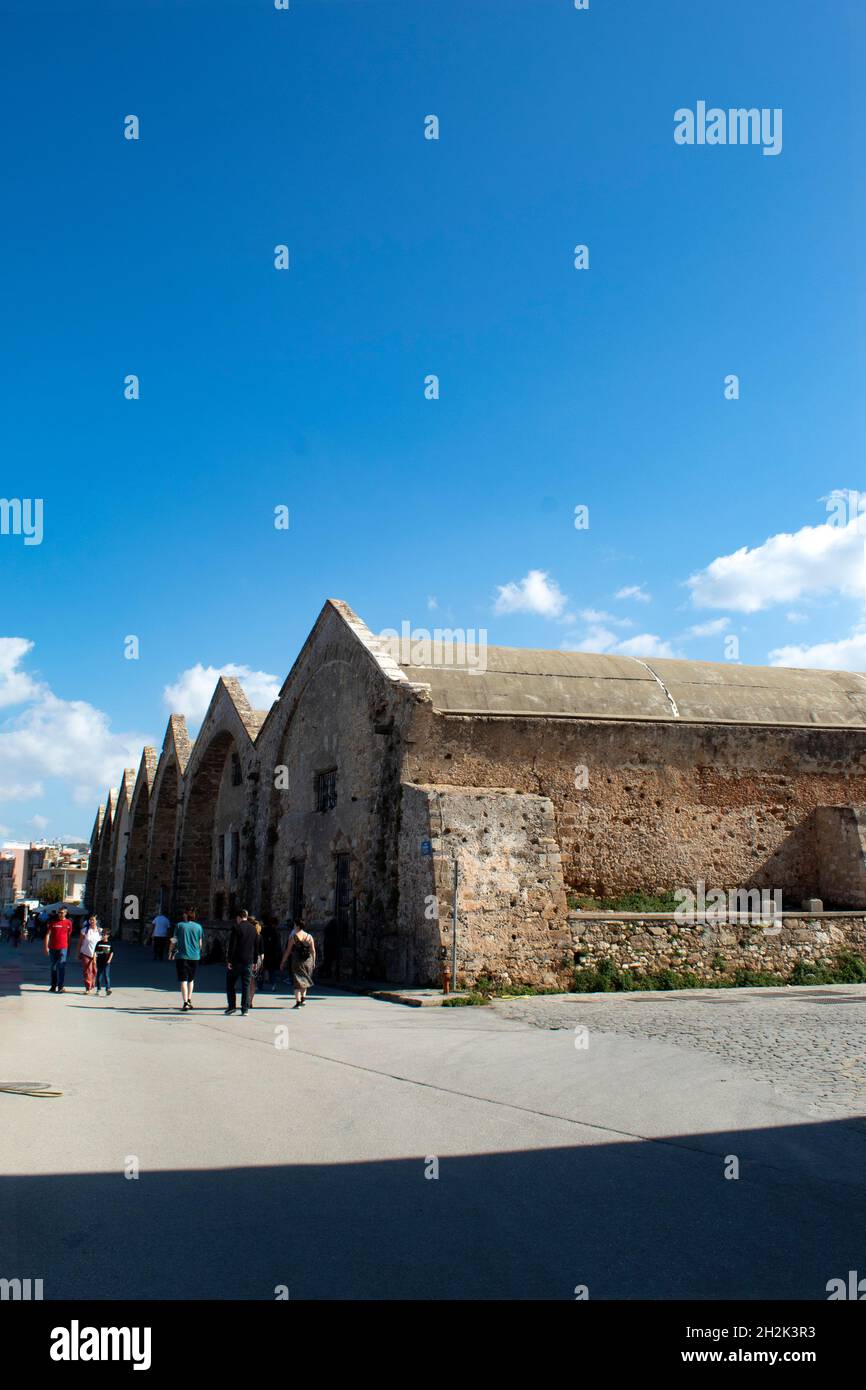 La città di Chania Creta l'antico Arsenale veneziano al bellissimo porto storico colpo verticale dell'antico edificio cielo blu e spazio copia Foto Stock