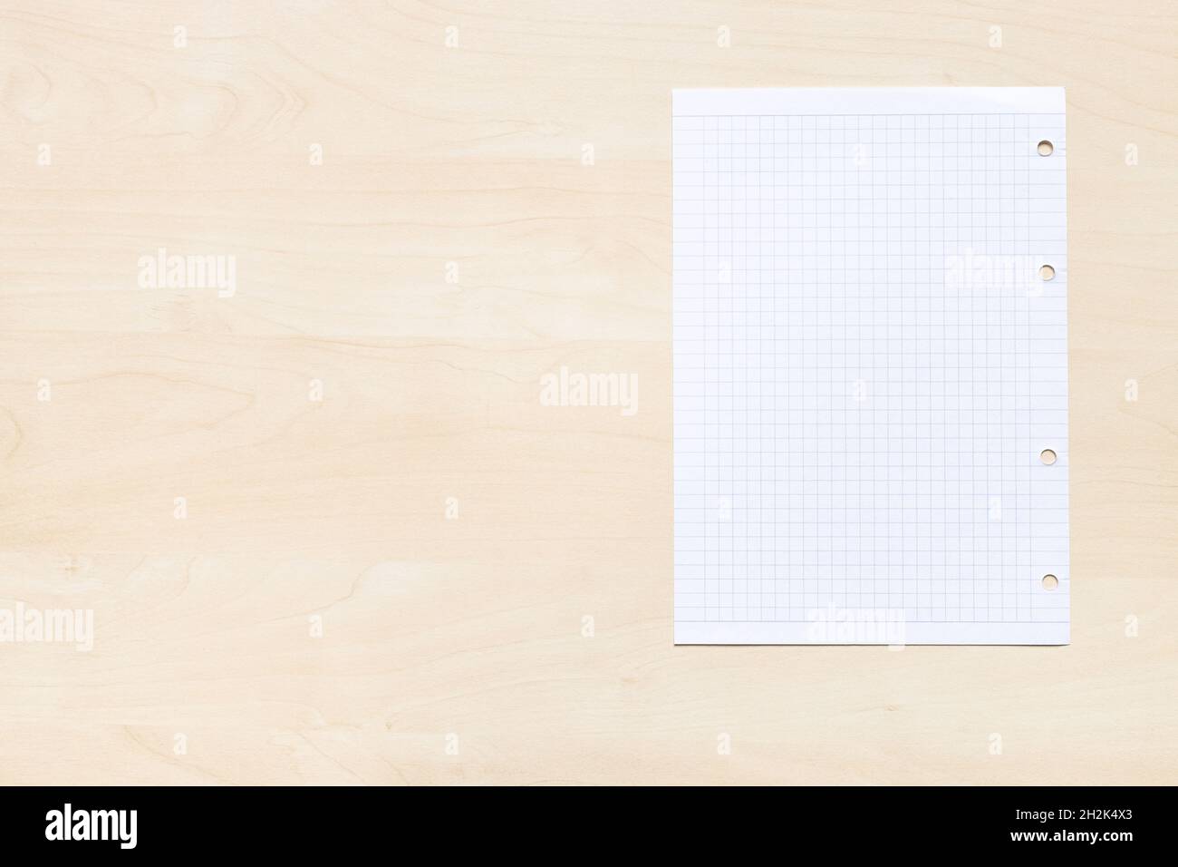 vista dall'alto di foglio bianco di carta quadrata su asse di legno marrone chiaro con copyspace Foto Stock