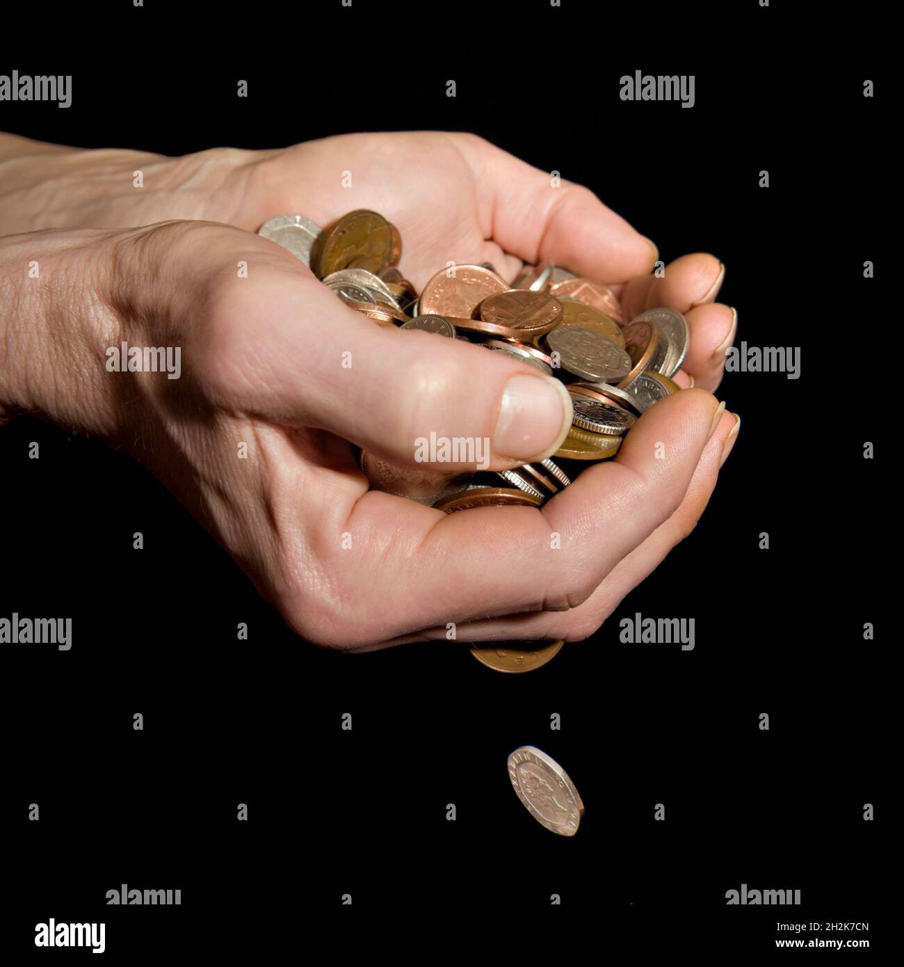 Il maschio caucasico (42 anni) ha mani con denaro che cadono raffigurando il concetto di “denaro che scivola attraverso le mani” o “troppo denaro da tenere” Foto Stock