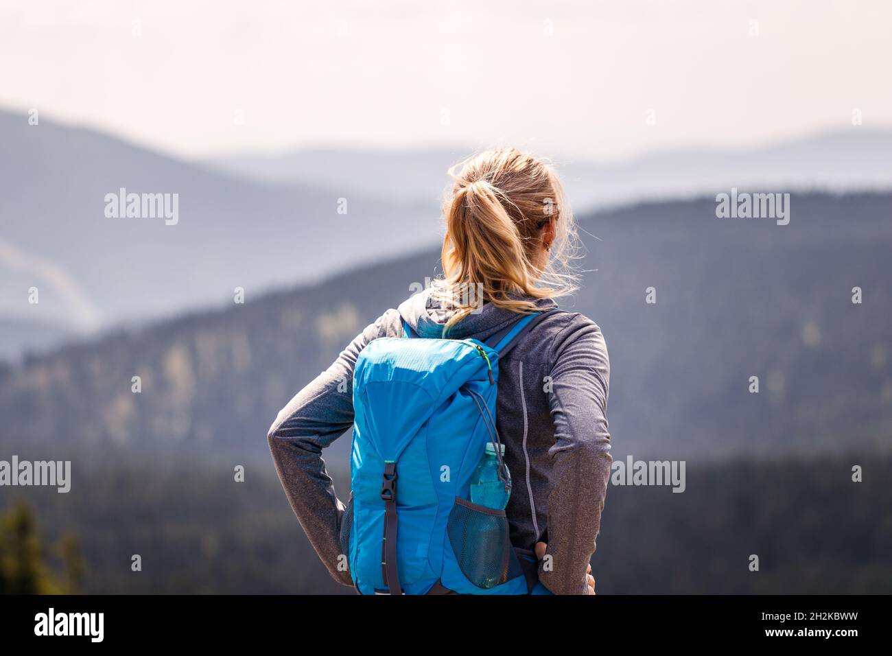 Escursione in montagna. Turista che gode di vista panoramica nella natura. Donna con zaino in piedi al picco della montagna. Stile di vita di viaggio e concetto di avventura Foto Stock