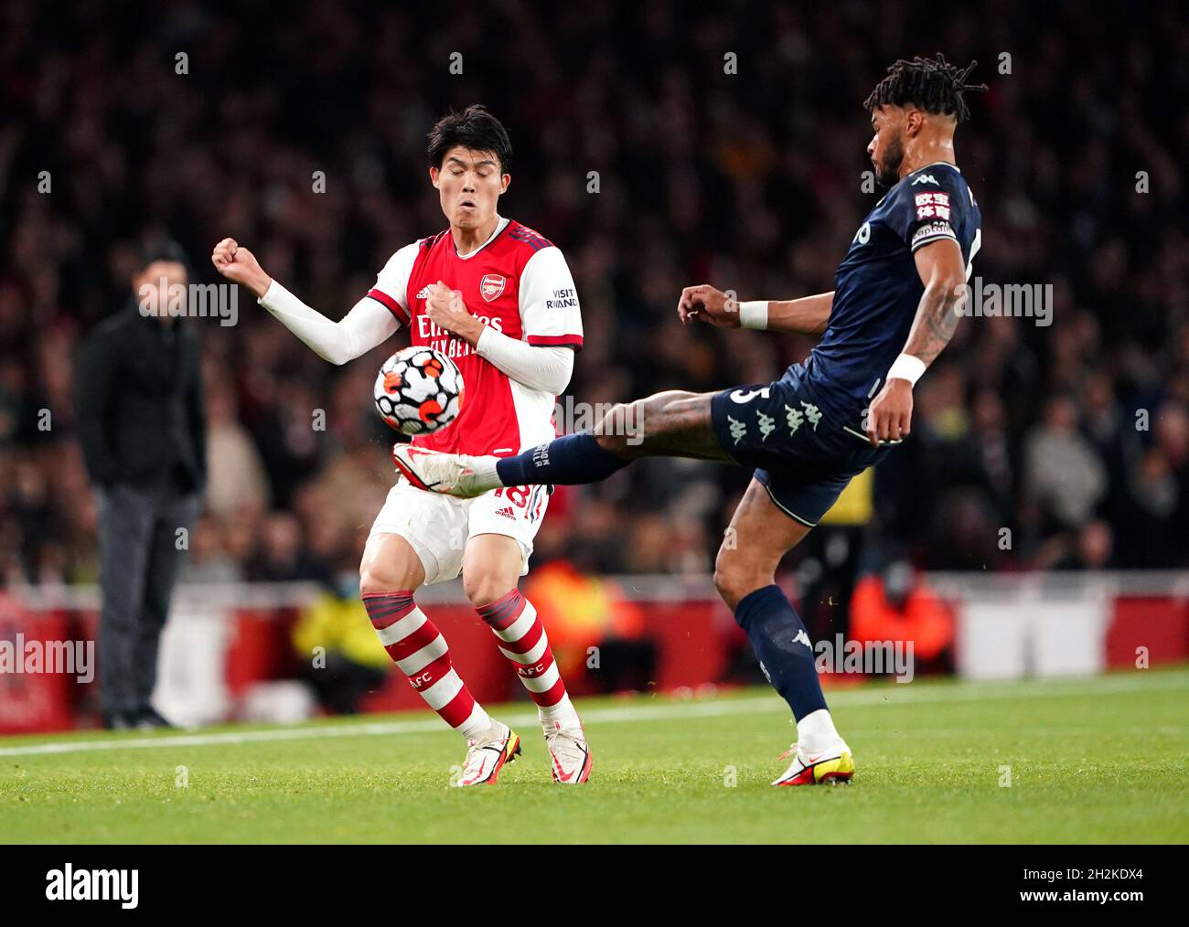 Il Takehiro Tomiyasu dell'Arsenal (a sinistra) e il Tyrone Mings dell'Aston Villa combattono per la palla durante la partita della Premier League all'Emirates Stadium di Londra. Data foto: Venerdì 22 ottobre 2021. Foto Stock