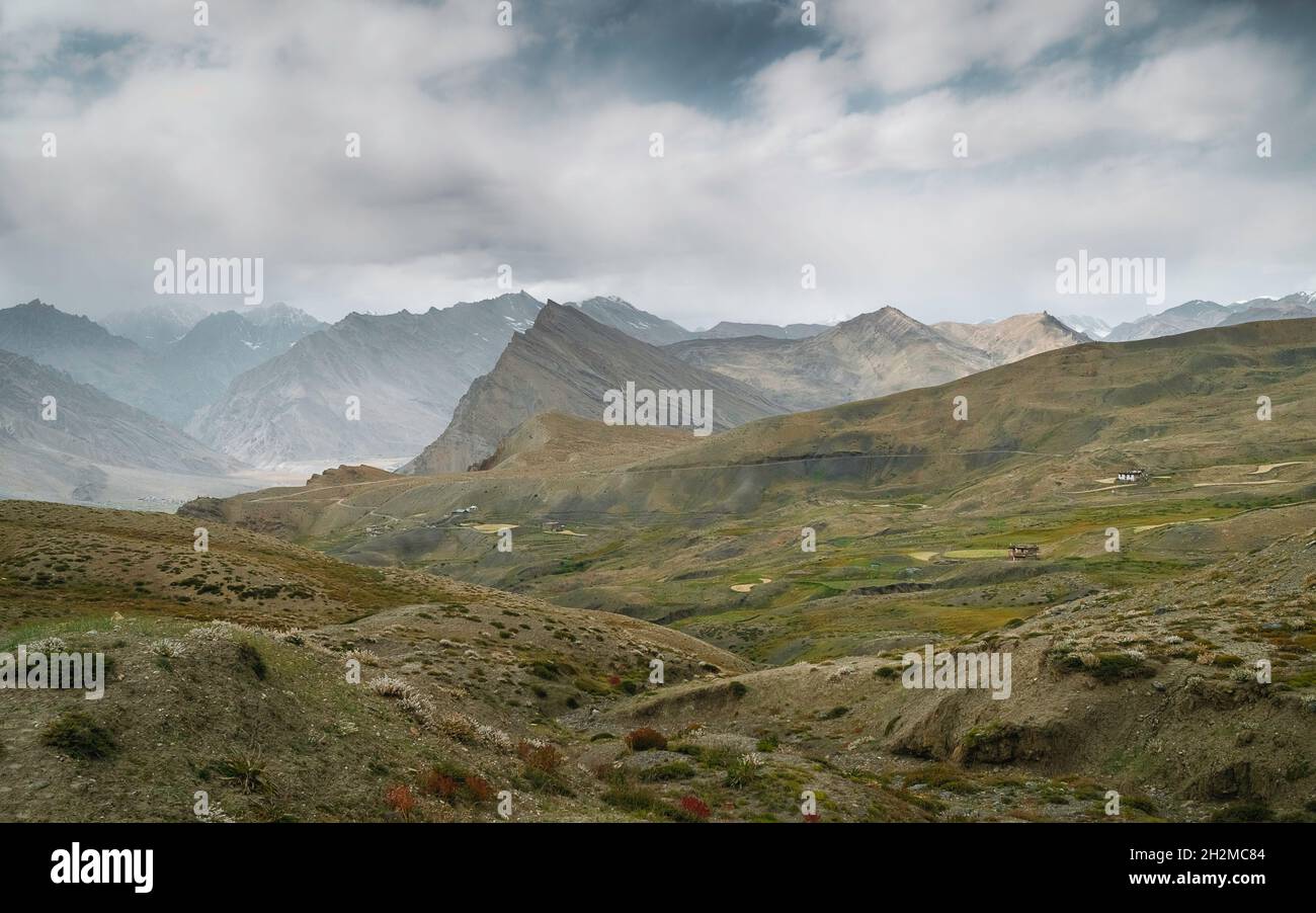 Paesaggio selvaggio con poche case sparse circondate da Himalaya nella valle di Spiti vicino al villaggio di Tashigang, Himachal Pradesh, India. Foto Stock