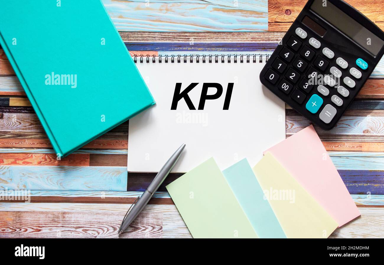 Notebook con testo KPI sul tavolo con calcolatrice, adesivi e blocco note buryus Foto Stock