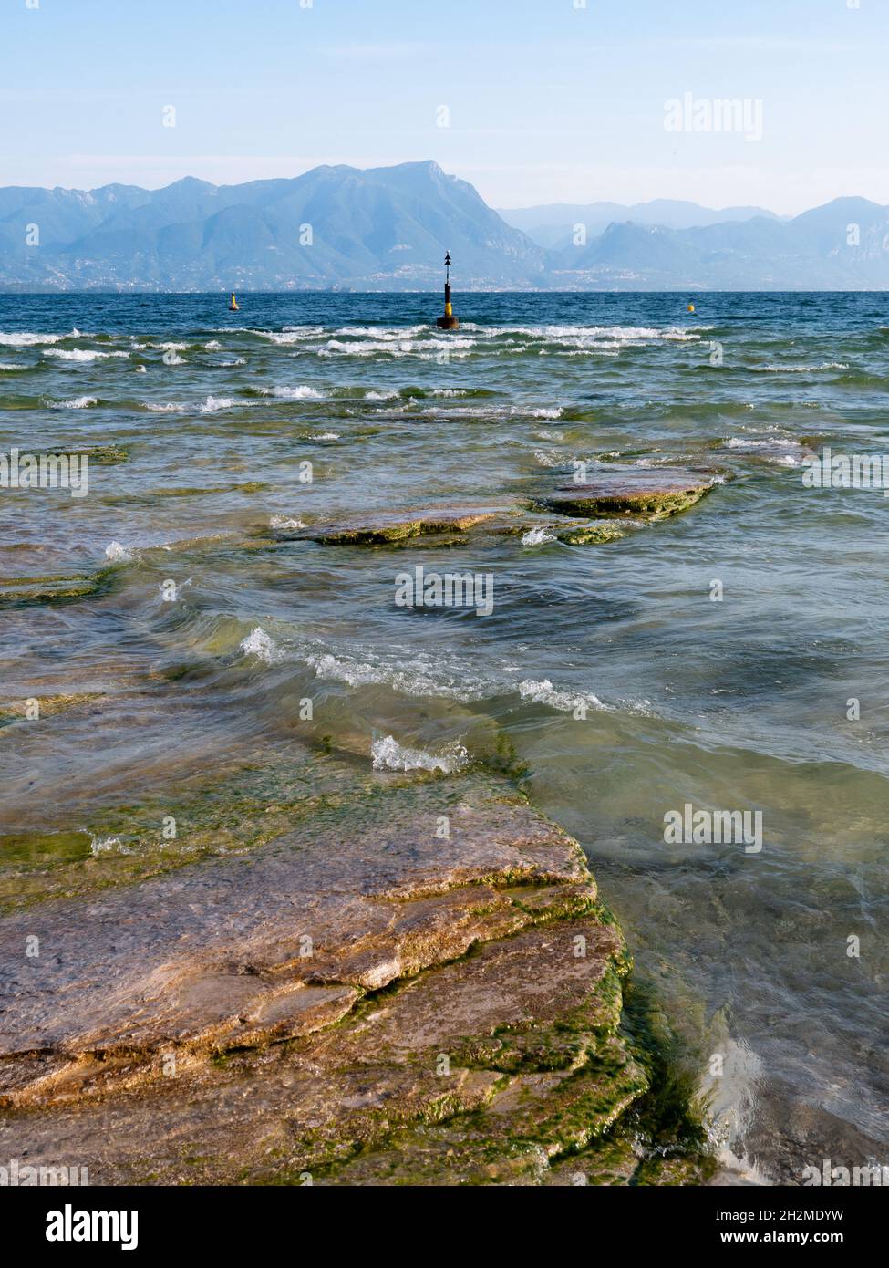 Spiaggia della Giamaica sul Lago di Garda nella Penisola di Sirmione, Italia con Buoy in mattinata estiva Foto Stock