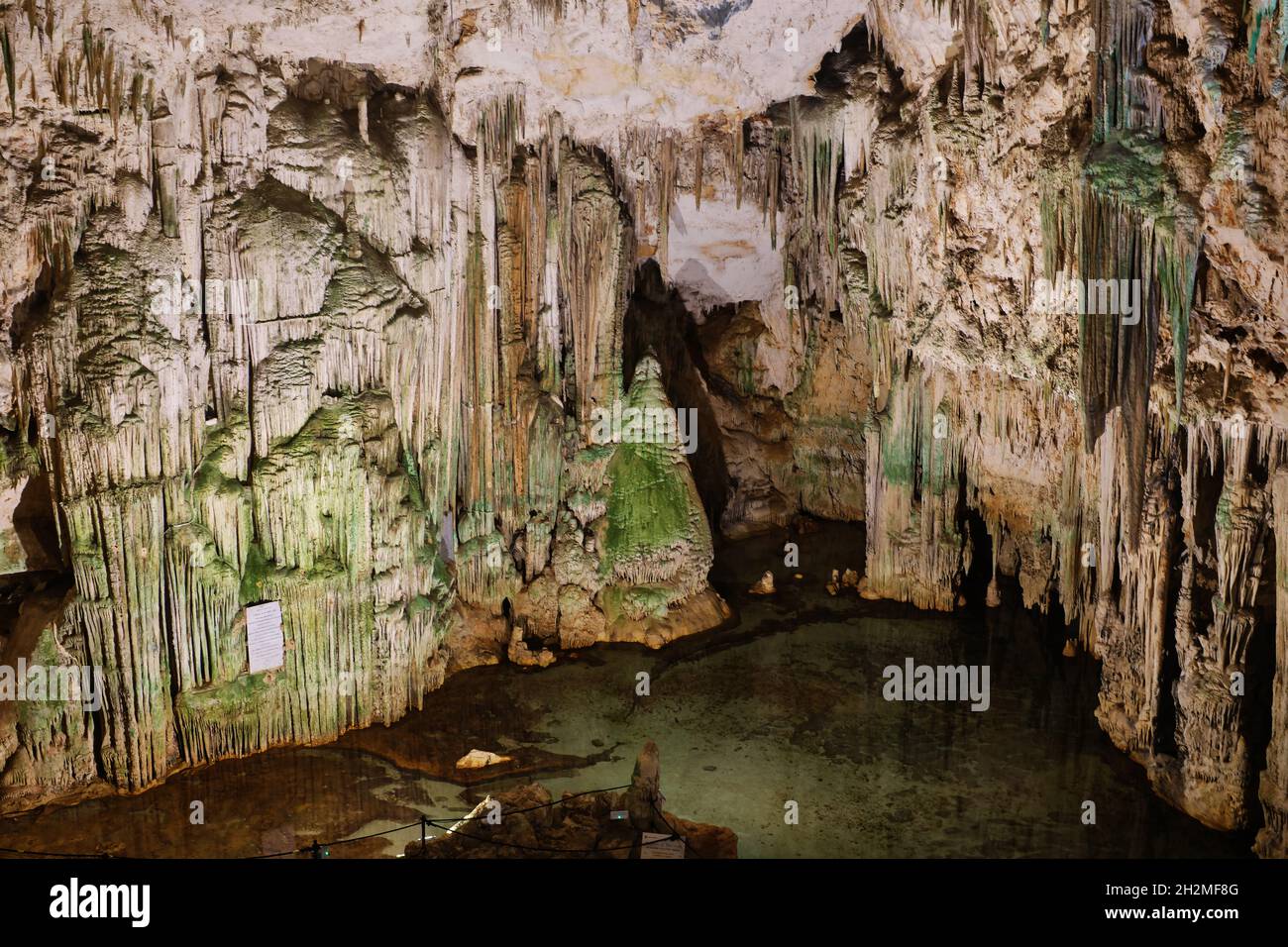 Antica grotta nel nord della Sardegna con lago interno, riflessi, stalattiti e stalagmiti Foto Stock