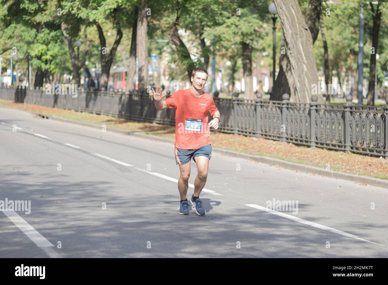DNIPRO, UCRAINA - 26 SETTEMBRE 2021: Uomo solitario felice che corre su una strada vuota della città durante 21 km di distanza di Almaz gruppo Dnipro Marathon Foto Stock