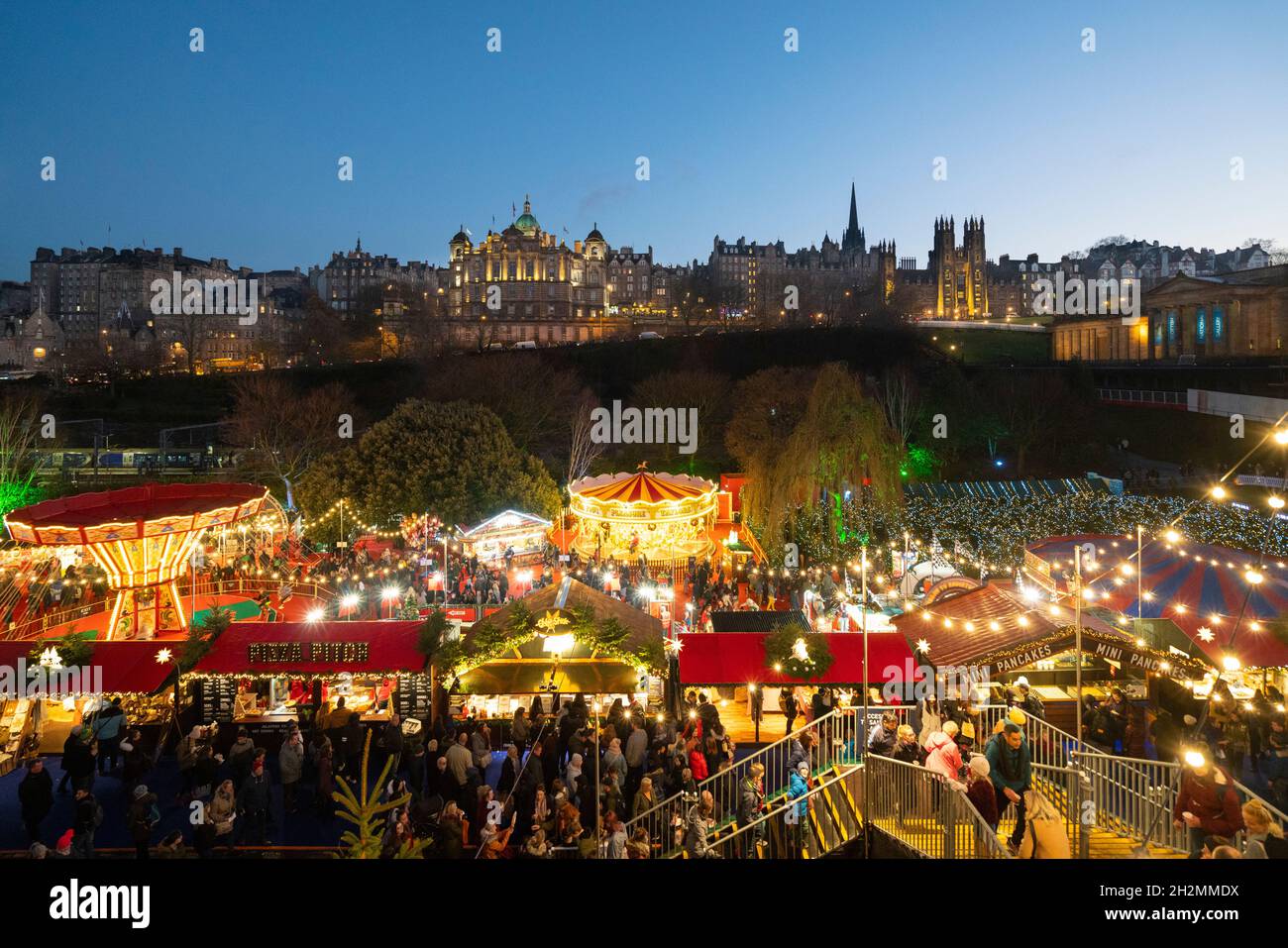 Vista del tradizionale mercato di Natale in serata a Princes Street Gardens, Edimburgo, Scozia, Regno Unito Foto Stock