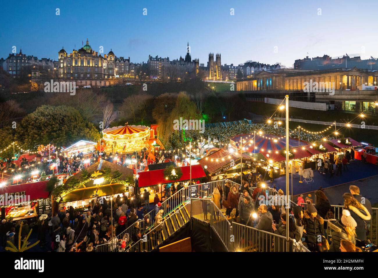 Vista del tradizionale mercato di Natale in serata a Princes Street Gardens, Edimburgo, Scozia, Regno Unito Foto Stock