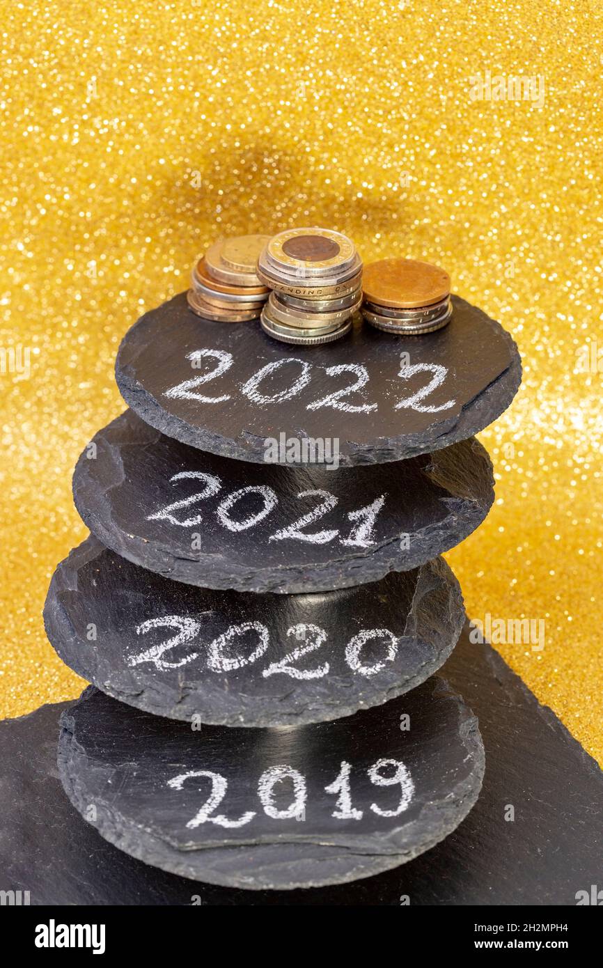 2022, 2021, 2020 e 2019 numeri scritti su piastrelle di pietra nera staked che rappresentano gli anni passati e futuri. Desideri di ricchezza per il nuovo anno Foto Stock