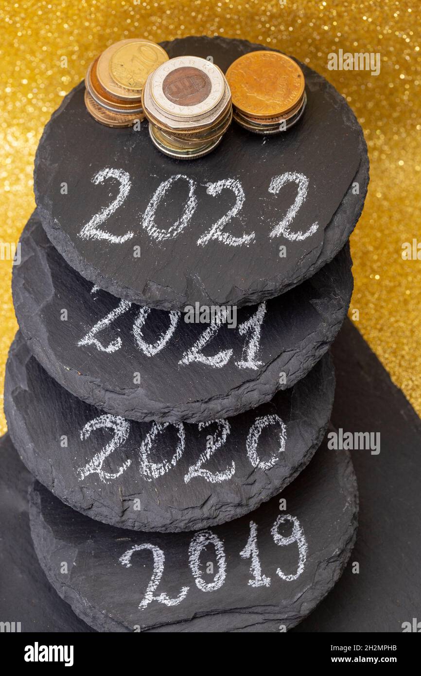 2022, 2021, 2020 e 2019 numeri scritti su piastrelle di pietra nera staked che rappresentano gli anni passati e futuri. Desideri di ricchezza per il nuovo anno Foto Stock