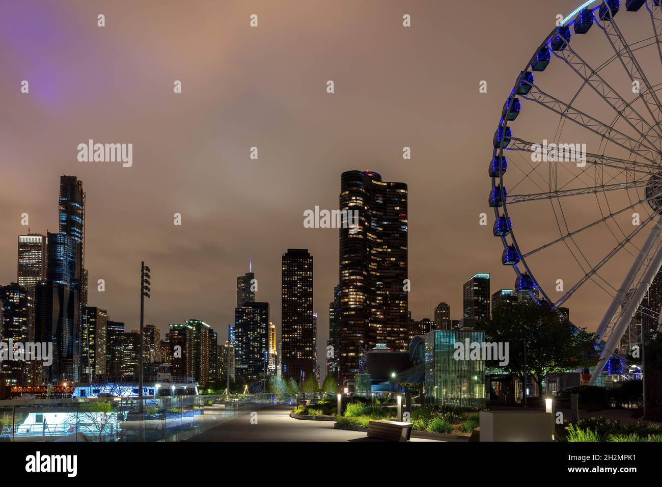Alti edifici della città di Chicago illuminati e Centennial Wheel presso il Navy Pier, sfondo di cielo nuvoloso. Illinois USA Foto Stock