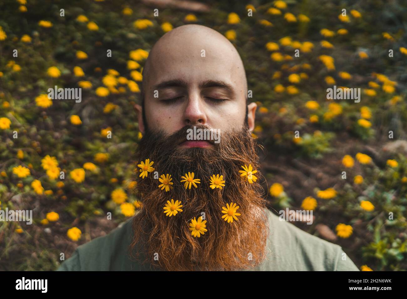 Giovane con fiori su barba marrone Foto Stock