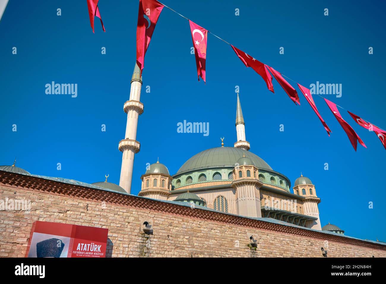 Moschea di Taksim, piazza taksim appesa sul poster di Ataturk di Mustafa Kemal, il suo nome in foto con moschea e minareto di recente costituzione. Foto Stock