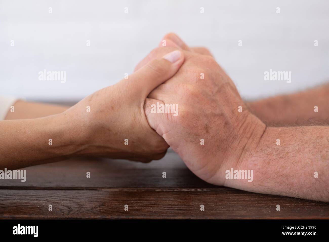 Coppia senior tenendo le mani sul tavolo Foto Stock Coppia senior tenendo le mani sul tavolo Foto Stock