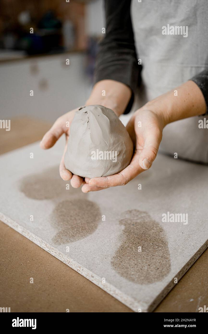Vasaio femmina che tiene argilla in officina Foto Stock